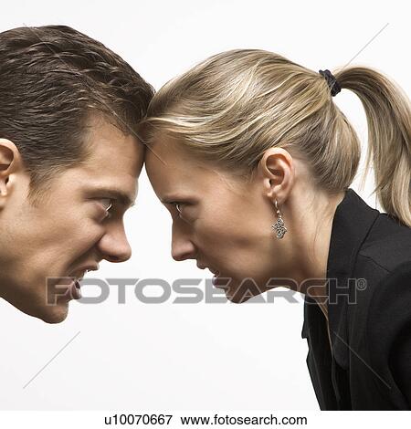Caucasian mid-adult man and woman with foreheads together staring at each other with hostile expressions. View Large Photo Image Stock Photo - Caucasian mid-adult man and woman with foreheads together staring at each other with hostile expressions.. Fotosearch