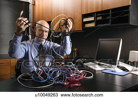 Caucasian middle-aged businessman at desk in office with a tangle of computer cables. View Large Photo Image Stock Image - Caucasian middle-aged businessman at desk in office with a tangle of computer cables.. Fotosearch