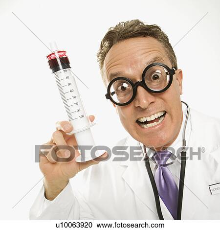 Mid-adult Caucasian male doctor wearing eyeglasses holding an oversized syringe. View Large Photo Image Stock Image - Mid-adult Caucasian male doctor wearing eyeglasses holding an oversized syringe.. Fotosearch