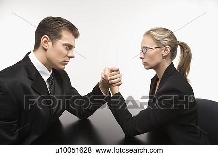 Side view of Caucasian mid-adult businessman and businesswoman arm wrestling on table. View Large Photo Image Stock Photo - Side view of Caucasian mid-adult businessman and businesswoman arm wrestling on table.. Fotosearch