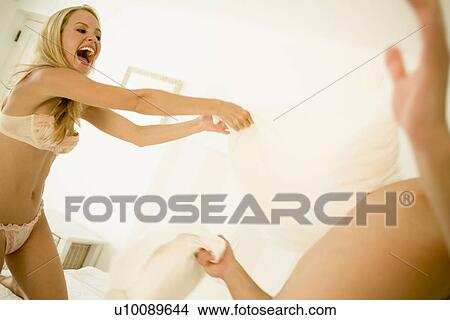 Couple in bedroom having pillow fight View Large Photo Image Picture - Couple in bedroom having pillow fight. Fotosearch
