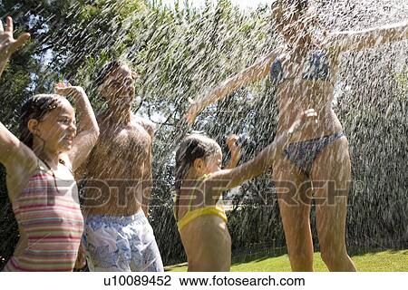 Stock Image - Family at home playing in garden. Fotosearch