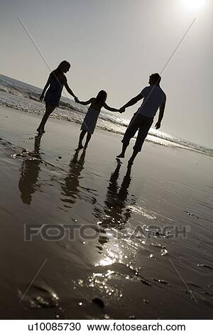 Stock Image - Family on beach playing together. Fotosearch