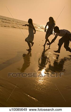 Family on beach playing together View Large Photo Image Stock Photo - Family on beach playing together. Fotosearch