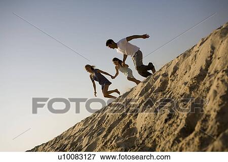 Family running over a sand dune View Large Photo Image Stock Photo - Family running over a sand dune. Fotosearch
