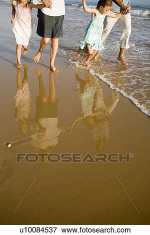 Stock Photo - Family walking on beach. Fotosearch