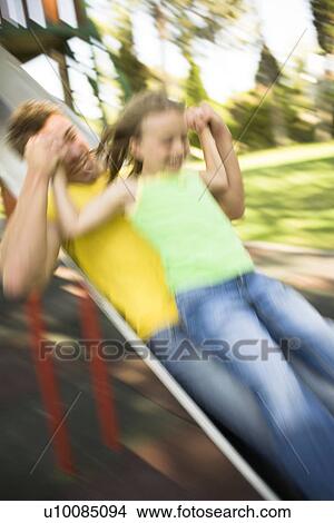 Picture - Father and daughter on slide. Fotosearch