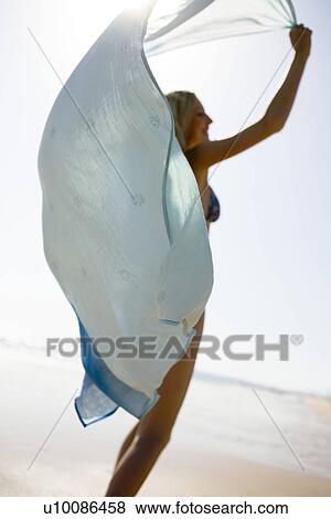 Stock Photo - Woman on beach with shawl. Fotosearch