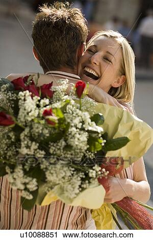 Couple embracing with flowers View Large Photo Image Stock Image - Couple embracing with flowers. Fotosearch