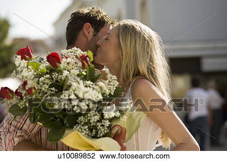 Couple embracing with flowers View Large Photo Image Stock Image - Couple embracing with flowers. Fotosearch