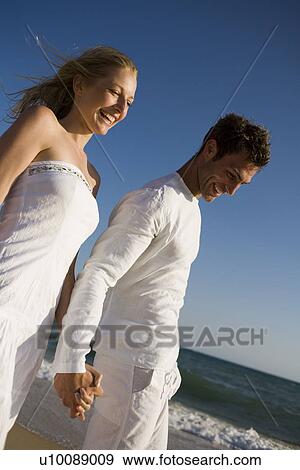 Stock Photo - Couple walking on beach. Fotosearch