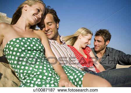 Two couples sitting on beach View Large Photo Image Stock Photo - Two couples sitting on beach. Fotosearch