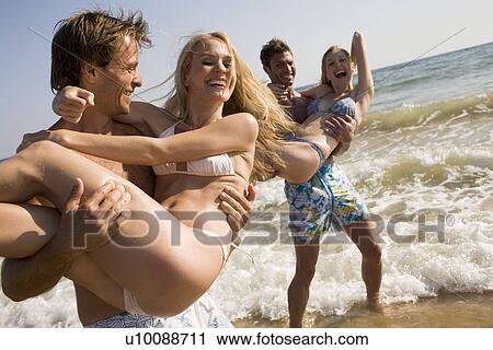 Stock Image - Two young couples on beach. Fotosearch