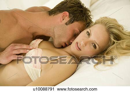 Stock Image - Young couple in bedroom. Fotosearch