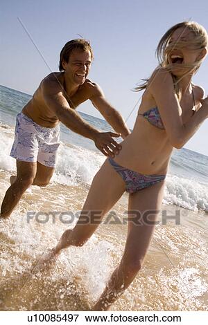 Stock Photo - Young couple on beach. Fotosearch