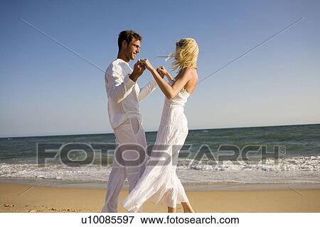 Stock Photo - Couple walking on beach. Fotosearch