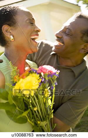 Stock Image - Mature couple with flowers. Fotosearch