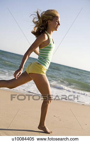 Stock Photography - Woman on beach running. Fotosearch