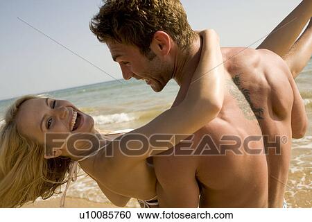 Young couple on beach View Large Photo Image Stock Image - Young couple on beach. Fotosearch