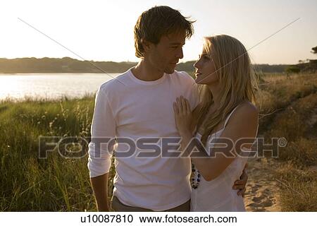 Young couple walking by lake View Large Photo Image Stock Image - Young couple walking by lake. Fotosearch