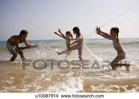 Family on beach playing together View Large Photo Image Picture - Family on beach playing together. Fotosearch
