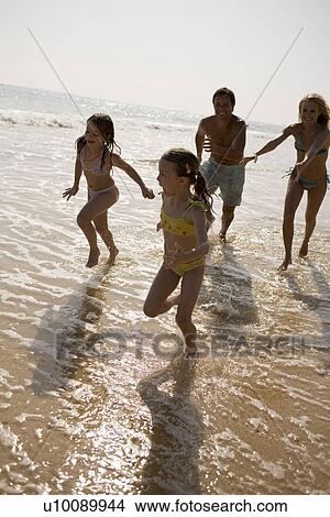 Picture - Family on beach playing together. Fotosearch