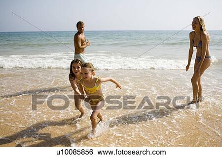 Family on beach playing together View Large Photo Image Stock Photograph - Family on beach playing together. Fotosearch