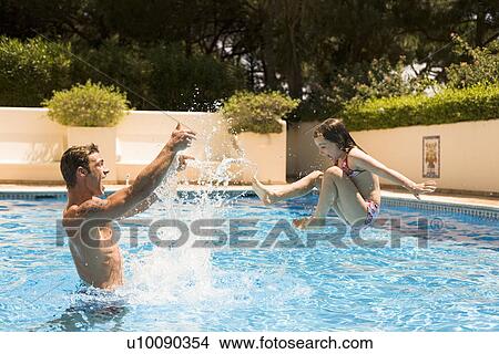 Picture - Father and daughter playing in pool. Fotosearch