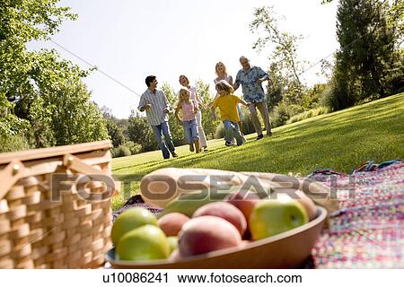 Stock Image - Grandparents and family in park. Fotosearch