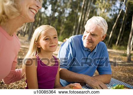 Picture - Grandparents and family in park with picnic. Fotosearch
