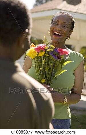 Stock Photo - Mature couple with flowers. Fotosearch