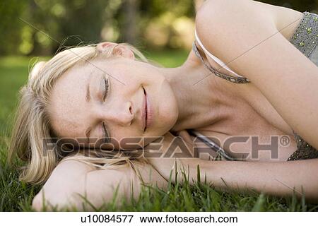 Woman lying down in grass View Large Photo Image Stock Photo - Woman lying down in grass. Fotosearch