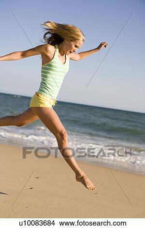 Picture - Woman on beach running. Fotosearch