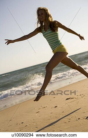 Picture - Woman on beach running. Fotosearch