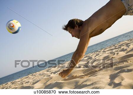 Man playing volleyball on beach View Large Photo Image Stock Image - Man playing volleyball on beach. Fotosearch