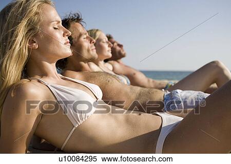 Two couples lying on beach View Large Photo Image Stock Photography - Two couples lying on beach. Fotosearch