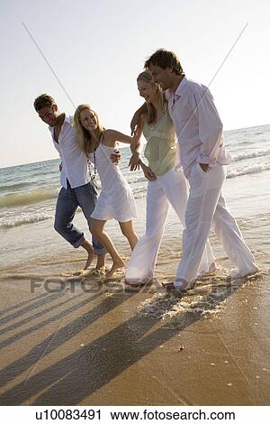 Stock Image - Two couples on beach. Fotosearch