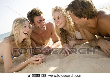 Stock Photo - Two couples playing on beach. Fotosearch