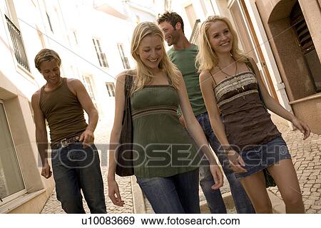 Two couples walking in town View Large Photo Image Stock Photo - Two couples walking in town. Fotosearch
