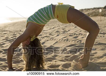 Stock Photography - Woman on beach doing exercise. Fotosearch