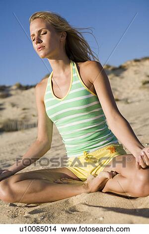 Picture - Woman on beach doing yoga. Fotosearch