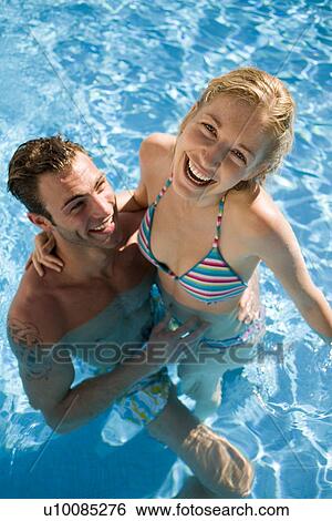 Young couple in pool View Large Photo Image Stock Photograph - Young couple in pool. Fotosearch