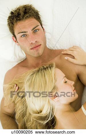 Young couple lying on bed View Large Photo Image Stock Photography - Young couple lying on bed. Fotosearch