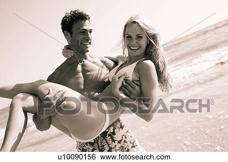 Stock Photograph - Young couple on beach. Fotosearch