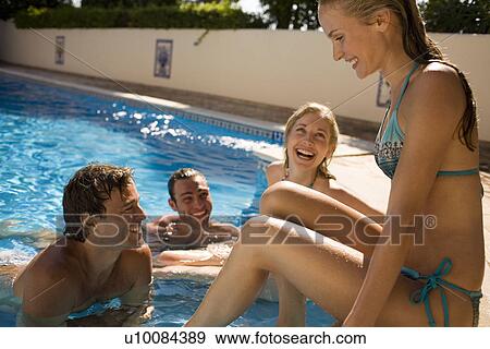 Stock Photo - Young couples by pool. Fotosearch