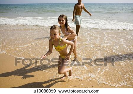 Stock Photo - Family on beach playing together. Fotosearch