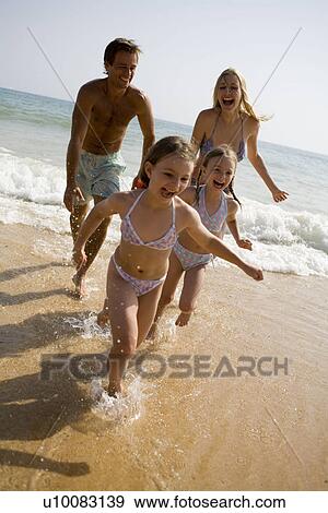Family on beach running out of sea View Large Photo Image Stock Photo - Family on beach running out of sea. Fotosearch