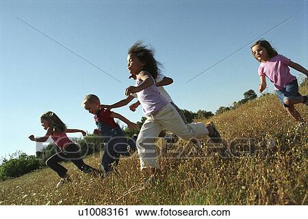 Stock Image - Five children running in field. Fotosearch