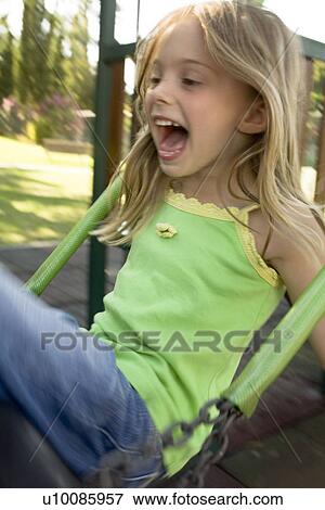 Stock Photo - Girl in Park on swing. Fotosearch