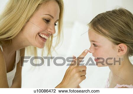 Mother applying makeup to young daughter's face View Large Photo Image Stock Image - Mother applying makeup to young daughter's face. Fotosearch